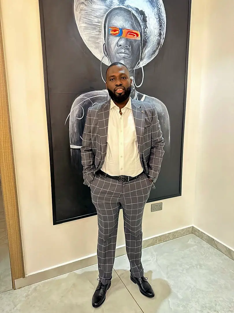 The Chief Executive Officer of Caritana Global Limited, standing in a grey checked suit